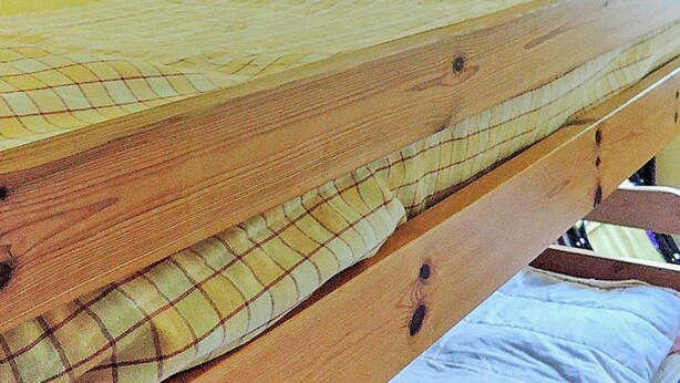 A wooden bed with a mattress and a pillow. - 6 Person Holiday Home in Hastveda (Hästveda)