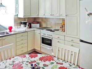A kitchen with white cabinets, a stove, oven, and a refrigerator. - 6 Person Holiday Home in Hastveda (Hästveda)
