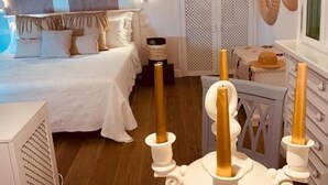A bedroom with a bed, bedside tables, and a dresser. There are candles on the dresser. - Deodato Apartments (Tropea)