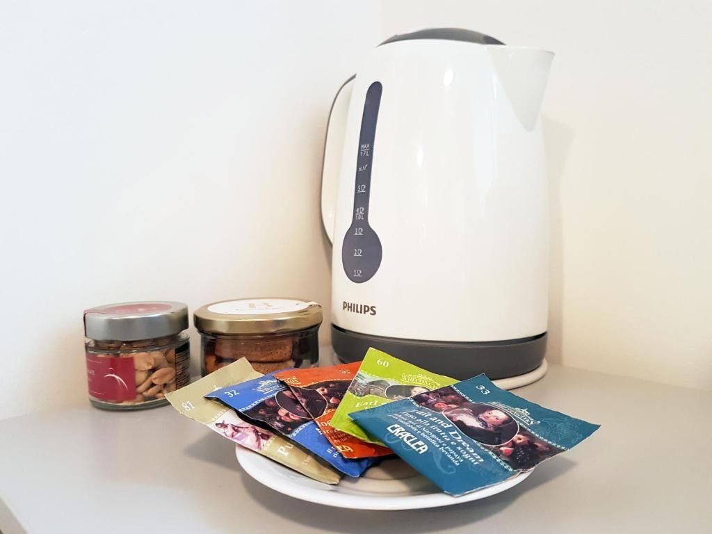 A white Philips coffee maker, two jars of food, and a plate with coffee pods.
