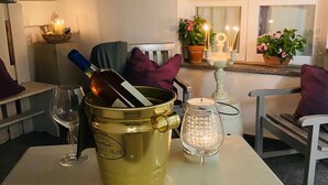 A dining table with a gold bucket, a wine glass, and a candle holder. - Deodato Apartments (Tropea)