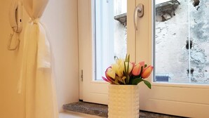 A white vase with flowers on a windowsill. - Deodato Apartments (Tropea)