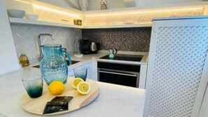 A modern kitchen with a marble countertop, a built-in sink, and a patterned backsplash. - Deodato Apartments (Tropea)
