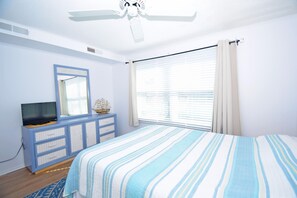 A bedroom with a bed, a dresser, a television, and a ceiling fan. - Old Wharf 15-AC,WIFI,W/D,Full kitchen (Ocean City)