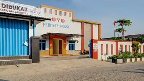 Un edificio con un letrero que dice "OYO PERMATA HOUSE" y una puerta azul.
