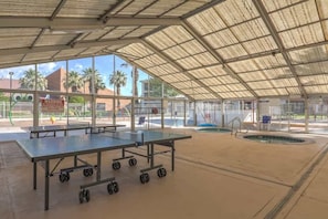 An indoor sports facility with multiple ping pong tables and a pool area. - Las Palmas Resort #2114 | All-Inclusive Amenities (Saint George)