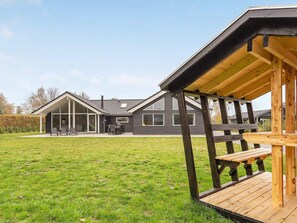Una casa moderna con una terraza amplia y un patio cubierto.