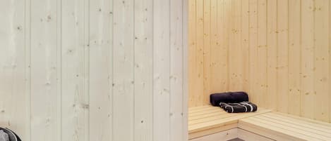 A sauna room with wooden walls and benches.