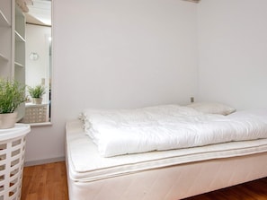 A bedroom with a bed, a mirror, and a potted plant. - 2 Person Holiday Home in Grasten (Grasten)