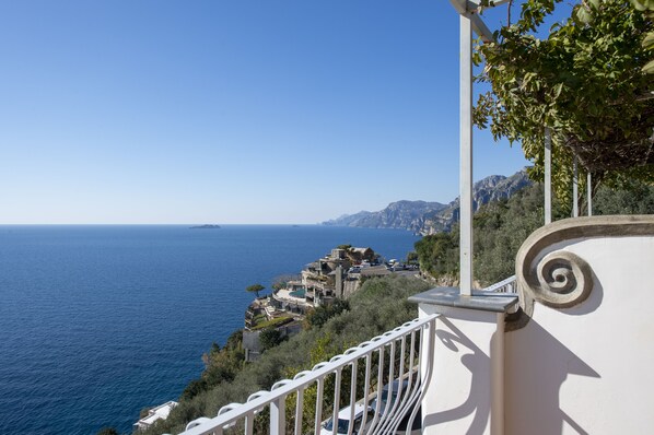 A coastal view with a balcony overlooking the sea and a hillside with buildings. - Il Barilotto (Positano)