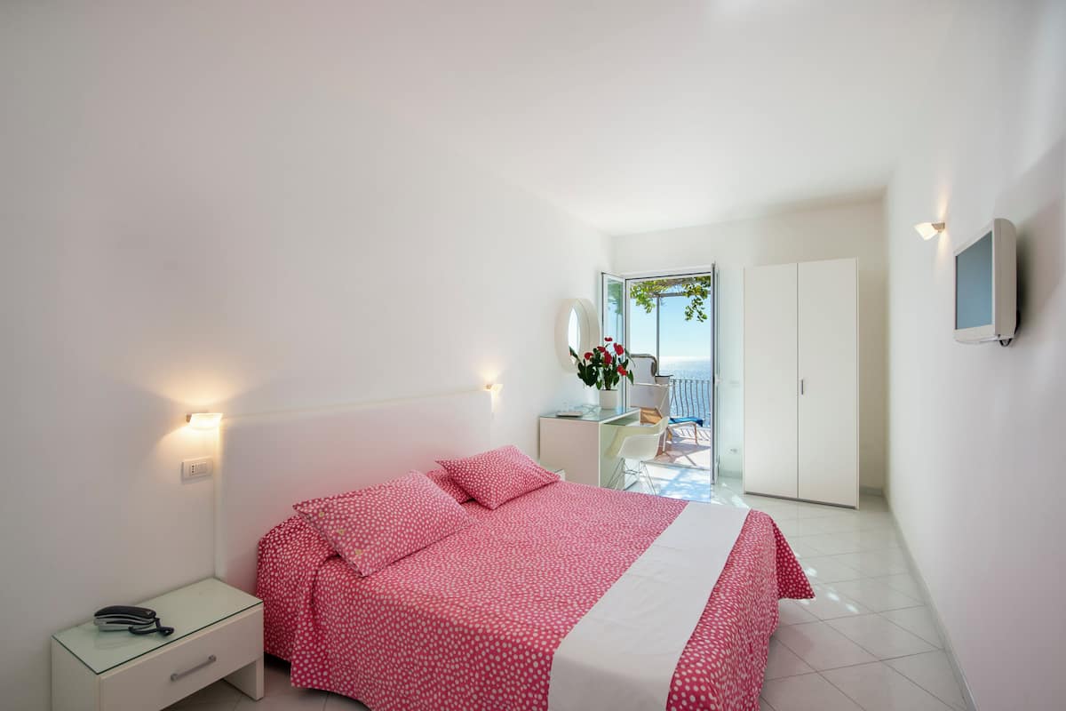 Ein Schlafzimmer mit Bett, Nachttisch und Schreibtisch mit Stuhl.