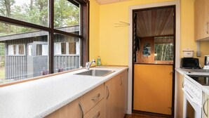 A compact kitchen with a window, a sink, and a stove.