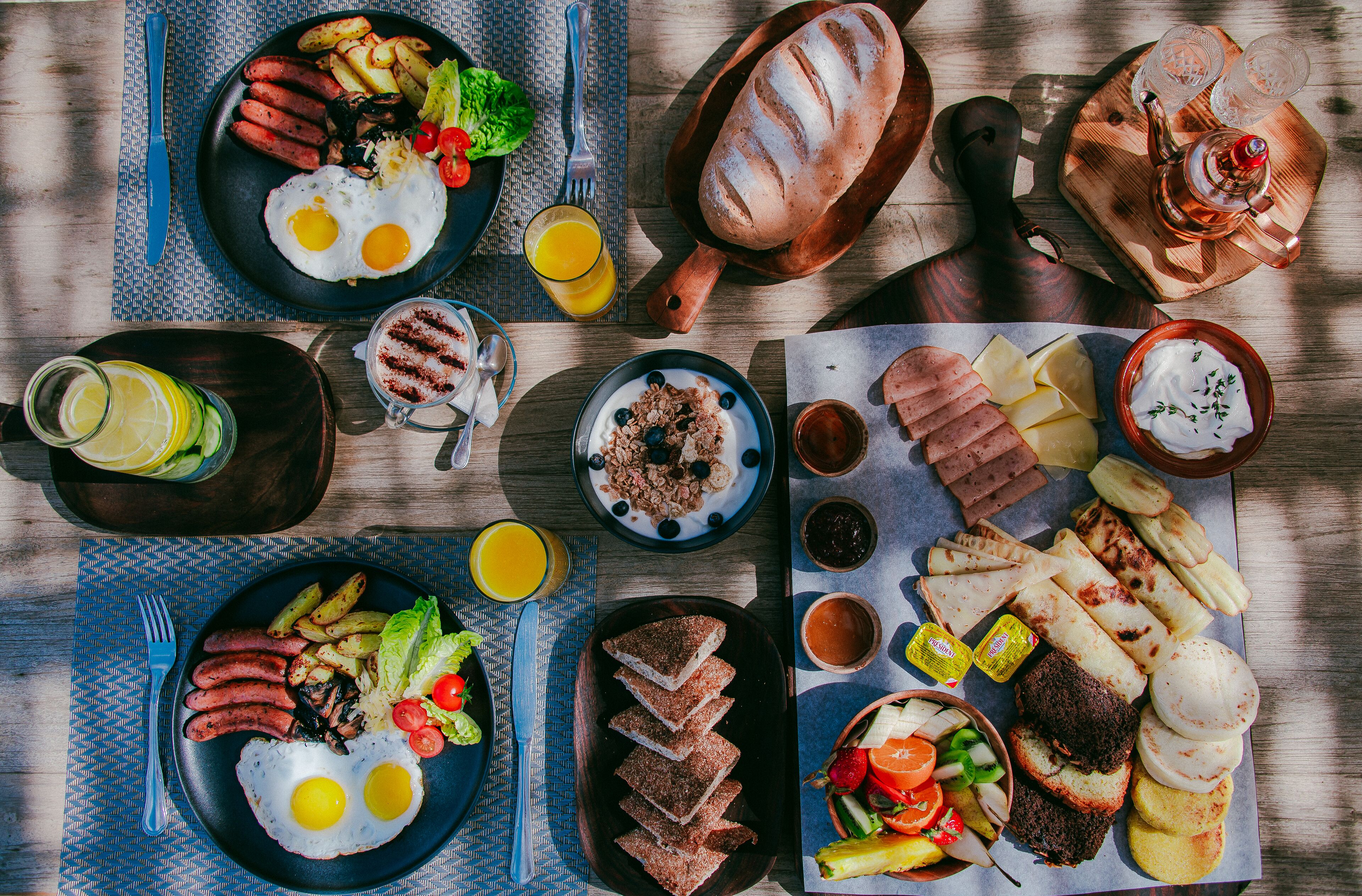 Ein reichhaltiges Frühstücksbuffet mit Speisen und Getränken auf einem Holztisch.
