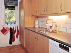 A kitchen with wooden cabinets, a stainless steel sink, and a Siemens dishwasher. - 6 Person Holiday Home in Ulfborg (Ulfborg)
