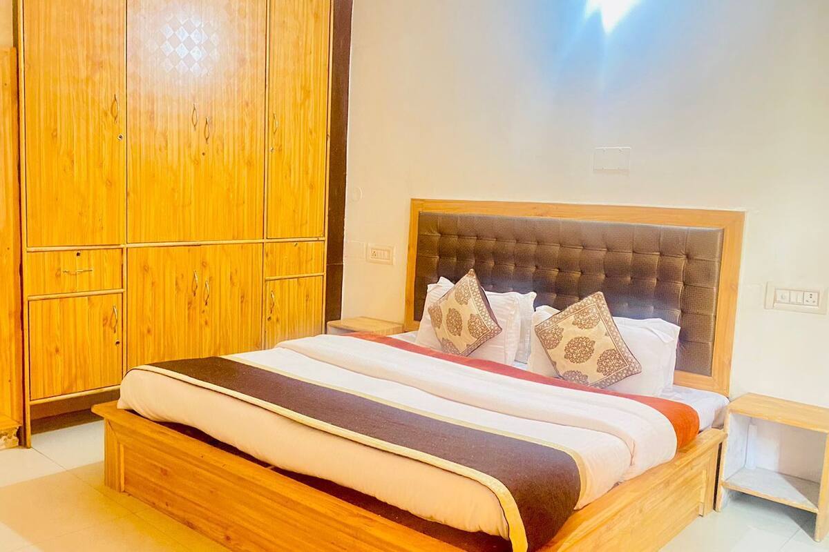 Un dormitorio con una cama de madera, un armario y una mesita de noche.