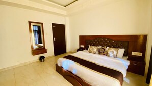 Un dormitorio con una cama grande, un cabecero de madera y una mesita de noche pequeña.