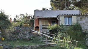 Une maison de campagne en pierre, dotée d’un petit porche et d’un escalier en pierre menant à l’entrée.