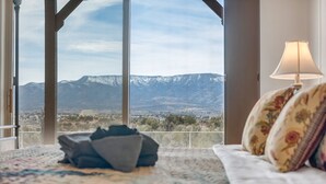 Un dormitorio con un ventanal que ofrece vistas a la montaña.