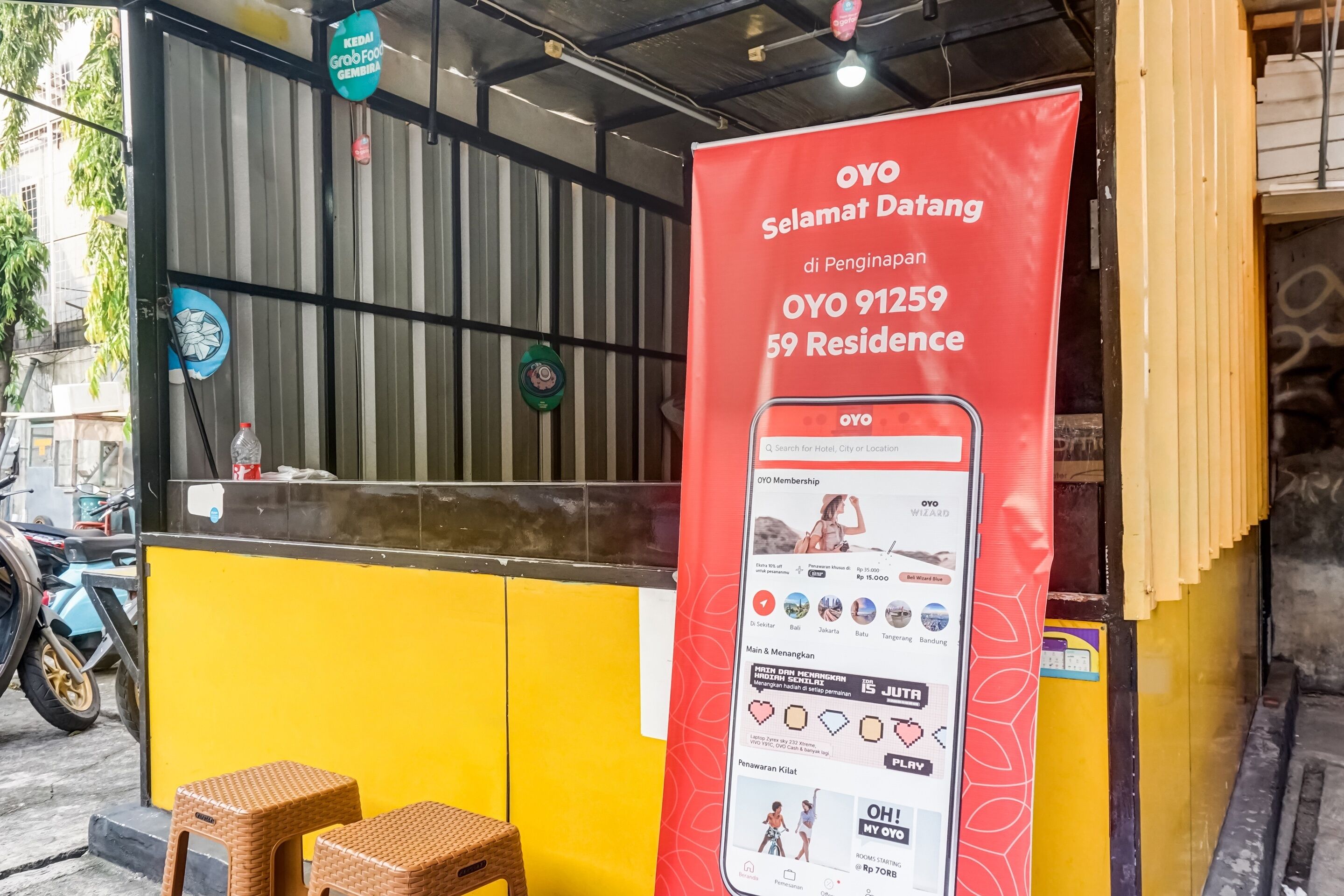 A yellow and black storefront with a red banner advertising OYO membership and a mobile app.