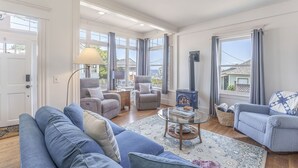Ein großzügiges Wohnzimmer mit einer großen Couch, zwei Sesseln, einem Couchtisch und einem Kamin.