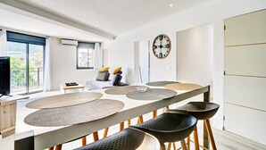 Ett modernt kök med en stor köksö, barstolar och en klocka på väggen.