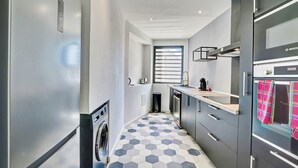 Ett modernt kök med ett kylskåp från Bosch, en tvättmaskin och en stor ugn.