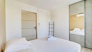 Ett modernt hotellrum med en stor säng, en garderob och en spegel.