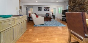 A spacious living room with a sofa, a coffee table, and a stone accent wall.