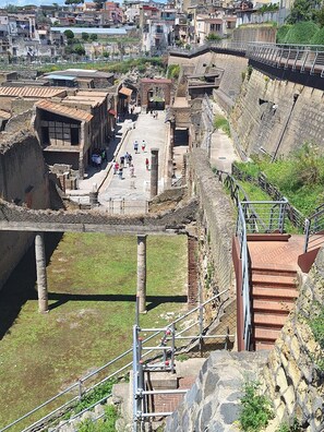 An ancient fortification with stone walls, a central courtyard, and a staircase leading up to a viewing platform. - GARDEN HOUSE ERCOLANO (Ercolano)