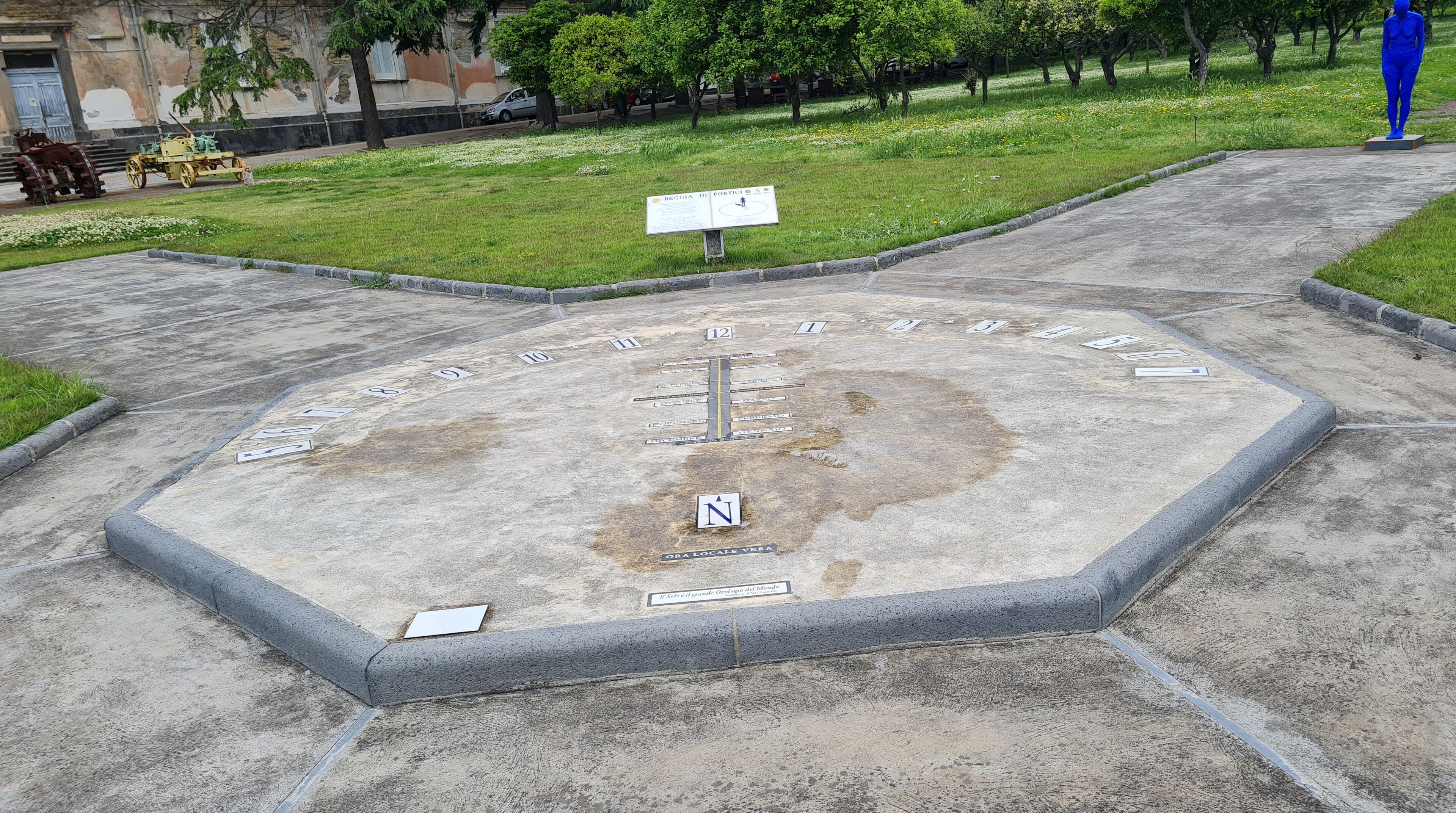 Una gran instalación de brújula al aire libre con marcadores numerados y una 'N' central que indica el norte.