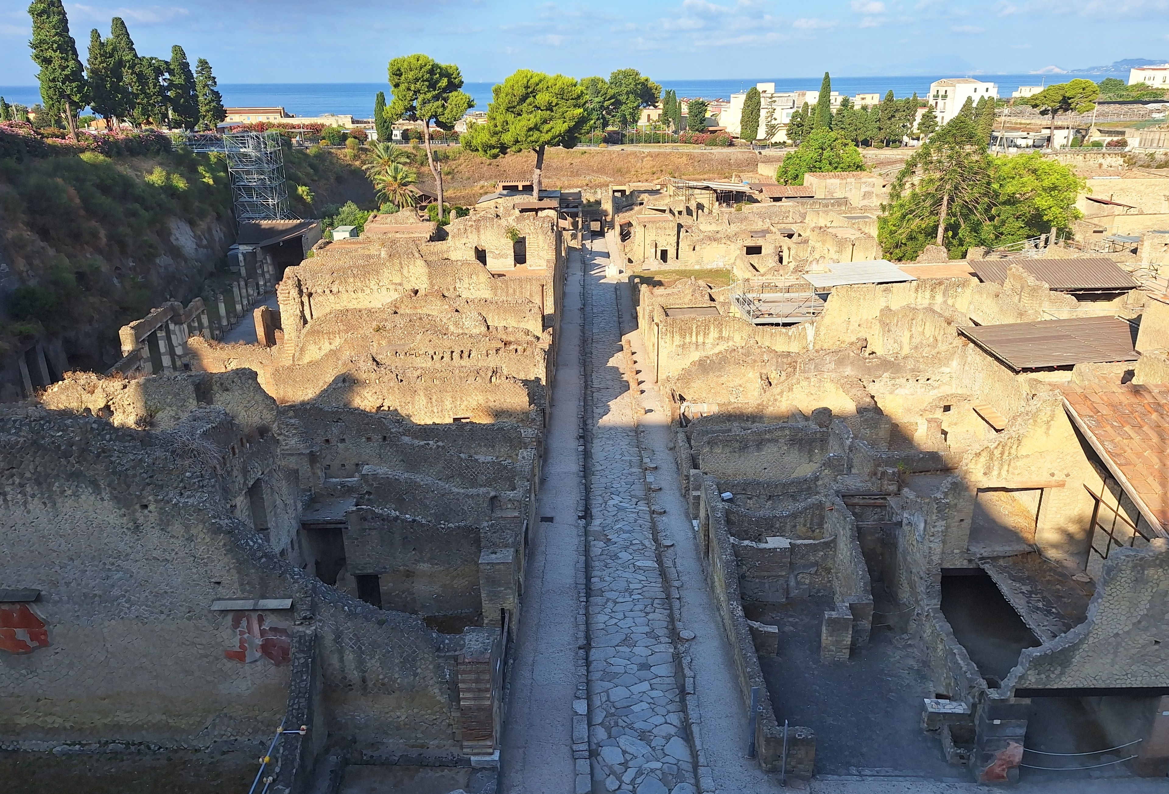 An archaeological site with ancient ruins and a paved pathway.