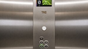 Un panneau de commande d’ascenseur avec des boutons permettant de sélectionner les étages, un écran numérique et un bouton d’appel.
