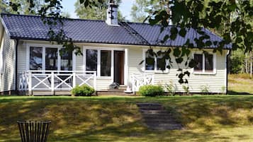 A single-story house with a porch, a chimney, and a small front yard.