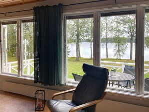 A room with a view of a lake, a chair, and a table outside. - 4 Person Holiday Home in Gislaved-by Traum (Gislaved)