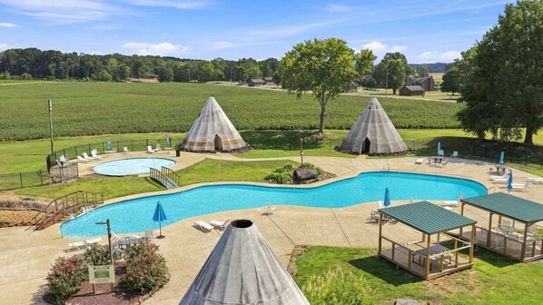 A swimming pool with two conical structures, lounge chairs, and a covered seating area. - Scenic Solitude - Doublehead (Town Creek)