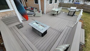 A deck with a fire pit, outdoor furniture, and a grill. - Sprawling 5 BR Chatham Escape / Endless Outdoor Living & Entertaining Choices (Chatham)