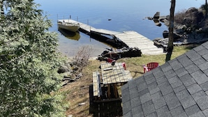 A dock extending into a calm lake with a forested shoreline.