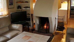 A cozy living room with a fireplace, leather sofas, a flat-screen TV, and a tiled coffee table. - 7 Person Holiday Home in Skyllberg (Skyllberg)
