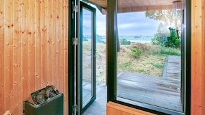 A wooden interior with a sliding glass door leading to an outdoor deck. - 5 Star Holiday Home in Millinge (Millinge)
