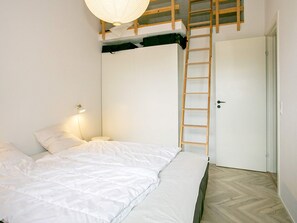 A bedroom with a bunk bed, a ladder, a bedside lamp, and a door. - 5 Star Holiday Home in Millinge (Millinge)