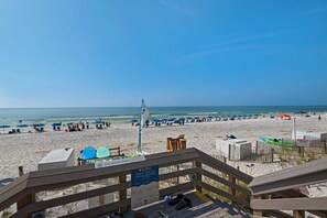 Ein Strand mit Sonnenschirmen, Liegestühlen und einem Holzzaun.