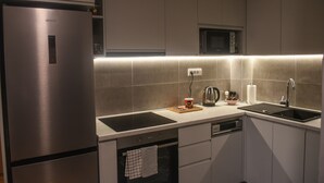 Cuina moderna amb electrodomèstics d'acer inoxidable, microones, rentaplat i màquina de rentavaixelles.
