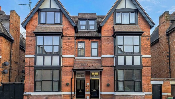 A two-story brick building with large windows and a central entrance.