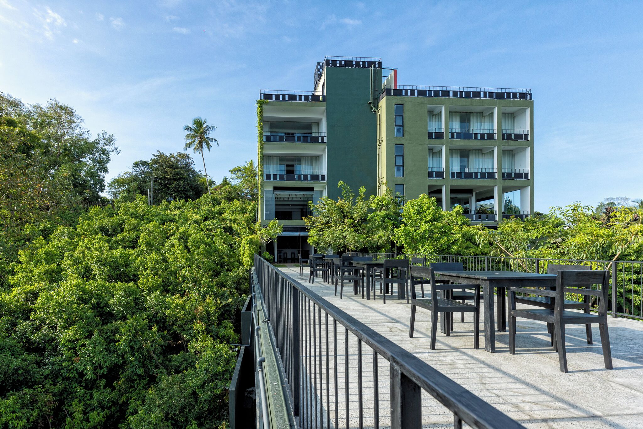 A multi-story building with balconies and a rooftop terrace.