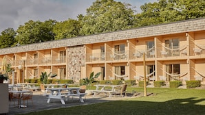Un motel con varias habitaciones, zona de estar al aire libre y jardín.