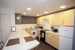 Una cocina compacta equipada con lavadora, microondas y refrigerador.