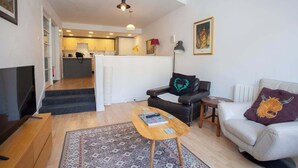 Un salon avec un canapé, une table basse et un meuble pour la télévision.