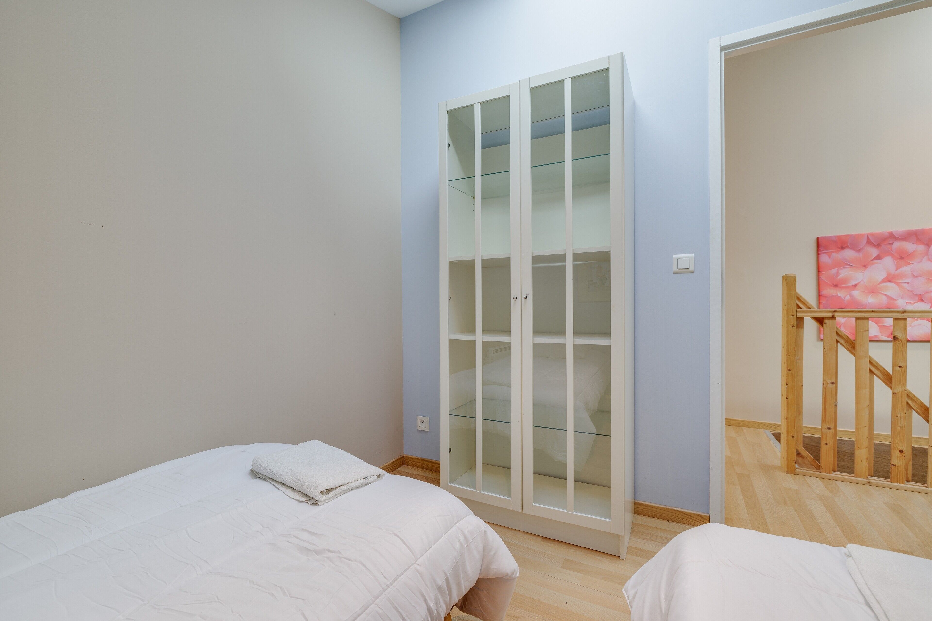 Een slaapkamer met een bed, een kledingkast en een trap.