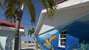 A building with a mural of a sea turtle and underwater scene, palm trees, and a clear sky. - NEWLY RENOVATED Beach studio w/ pool view #4 (Treasure Island)
