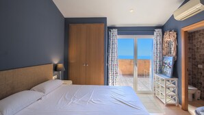 A bedroom with a bed, a wardrobe, a nightstand, a lamp, a bathroom, and a view of the outside. - Holiday Home 'Casa Marbello - Begur' with Sea View, Pool, Terrace & Wi-Fi (Begur)